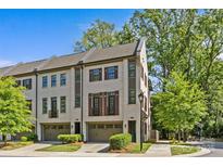 Beautiful exterior view of brick townhomes with attached garages and lush green landscaping at 2906 Hillside Springs Dr, Charlotte, NC 28209