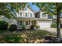 Charming two-story home featuring a well-maintained lawn, a covered front porch, and an attached two-car garage at 3664 Privette Rd, Matthews, NC 28104