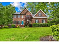 Beautiful two-story brick home with a well-manicured lawn and a charming blue front door at 4339 Shannamara Dr, Matthews, NC 28104