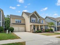 Charming two-story home featuring a two-car garage, well-manicured lawn, and a welcoming front porch with rocking chairs at 5013 Hamilton Mill Dr, Waxhaw, NC 28173