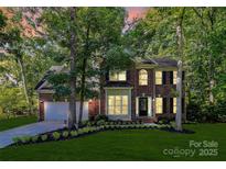 Charming brick two-story home with a well-manicured lawn and mature trees at 516 Aspen Ln, Indian Trail, NC 28079