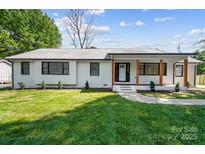 Charming brick home with landscaped yard, wood accents, and inviting entrance at 5428 Barnsdale Ln, Mint Hill, NC 28227