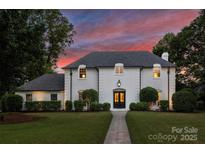Stunning two-story white brick home with manicured lawn and beautiful trees at 5806 Bentway Dr, Charlotte, NC 28226