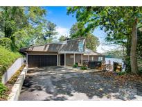 Inviting exterior with a two-car garage and lake access, set against a backdrop of lush, mature trees at 6664 Lake Shore Dr, Hickory, NC 28601