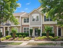 Charming townhome with stone accents, manicured landscaping, and inviting front entrance at 8037 Lynwood Sq, Waxhaw, NC 28173