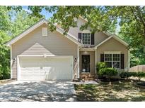 Charming home featuring a well-manicured lawn, attached garage, and traditional architectural details at 8347 Fox Swamp Rd, Charlotte, NC 28215