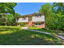 Charming split-level home featuring a well-maintained lawn and mature trees, creating a serene and inviting atmosphere at 11861 Nc Hwy 73 E Hwy, Mount Pleasant, NC 28124