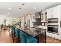 Modern kitchen features a large island with seating and pendant lighting at 13022 Simoneaux Ln, Charlotte, NC 28277