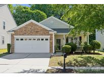 Charming single-story home featuring a stone facade, attached two-car garage, and well-manicured landscaping at 1622 Candlewood Ridge Ln, Matthews, NC 28105