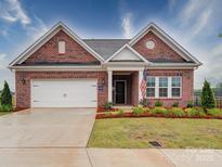 Charming red brick home featuring a two-car garage, landscaped yard, and inviting front entrance at 3069 Founding Fathers Dr, Gastonia, NC 28056