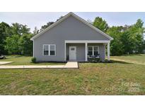 Charming single-story home with gray siding, a covered porch, and a well-manicured lawn at 325 Cornwall Dr, Salisbury, NC 28147