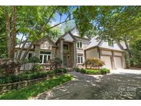 Stunning stone home with a two car garage and mature landscaping providing curb appeal and natural shade at 3932 Rounding Run Rd, Charlotte, NC 28277