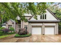 Stunning stone and shingle home with a two-car garage, complemented by lush landscaping and mature trees at 3932 Rounding Run Rd, Charlotte, NC 28277