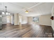 Bright living room featuring modern floors, fresh paint, and ample natural light from windows at 5001 Grand Canyon Nw Rd, Concord, NC 28027