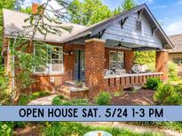 Charming brick home featuring a cozy front porch with stylish seating and a lush landscaped yard at 510 Wiley Ave, Salisbury, NC 28144