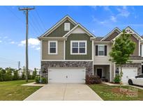 Inviting townhome featuring a stone-accented front, two-car garage, and a well-manicured lawn at 5207 Maynard Hill Dr, Monroe, NC 28110