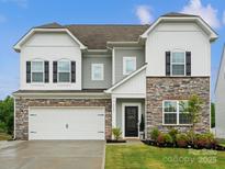 Charming two-story home featuring a stone facade, black shutters, and a manicured lawn at 5581 Soft Shell Dr, Lancaster, SC 29720