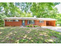 Charming brick ranch home featuring a carport, mature trees and nicely landscaped front yard at 619 E Sanders Rd, Shelby, NC 28150
