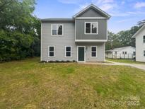 Charming two-story home with gray siding, green front door, and freshly planted landscaping at 746 Shasta Nw St, Concord, NC 28027