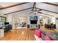 Spacious living room with hardwood floors, wooden beam ceiling and open floor plan view of dining and kitchen at 8544 Houston Ridge Rd, Charlotte, NC 28277
