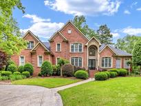 Stately brick home featuring manicured lawn and mature landscaping at 1200 Firethorne Club Dr, Waxhaw, NC 28173