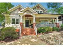 Charming home with a inviting brick staircase leading to a cozy covered porch with hanging flower baskets at 1701 Dearmon Dr, Charlotte, NC 28205