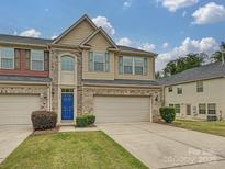 Charming townhome with a blue front door, two-car garage, brick and siding, and well-maintained landscaping at 1769 Evergreen Dr, Charlotte, NC 28208