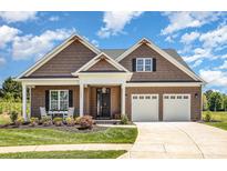 Charming home featuring a well manicured lawn, rocking chair front porch, and a two-car garage at 19031 Brandon James Dr, Cornelius, NC 28031