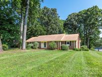 Charming brick home with a manicured lawn and mature trees in a serene and inviting neighborhood at 2222 Hearthstone Dr, Gastonia, NC 28056