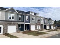 Charming townhomes featuring stone accents, attached garages, and coordinated gray and blue color scheme at 2535 Ruby Dixon Crossing Dr # 19, Gastonia, NC 28056