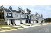 View of new townhomes with stone accents, individual garages, and neatly landscaped lawns at 2535 Ruby Dixon Crossing Dr # 19, Gastonia, NC 28056