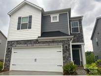 Two-story home featuring gray and white siding, stone accents, and a two-car garage at 345 Hyssop Ct, Fort Mill, SC 29715