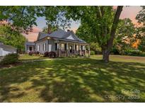 Charming home featuring a large front yard and a welcoming front porch with stone pillars at 4960 York Hwy, Rock Hill, SC 29732