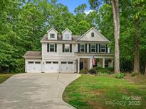 Inviting two-story home with a three-car garage and a welcoming front porch, surrounded by mature trees at 5308 Lambert Ct, Waxhaw, NC 28173