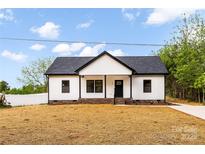 Charming single-story home boasts a newly installed roof and freshly painted white siding at 605 Stirewalt Rd, China Grove, NC 28023
