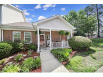 Charming brick home with a inviting front porch and well-manicured landscaping at 614 Stone Village Dr, Fort Mill, SC 29708