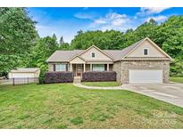 Charming brick home with well-manicured lawn, mature trees, and inviting curb appeal at 7020 Cedar Ridge Ct, Mount Holly, NC 28120