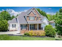 Charming two-story brick home with well-maintained landscaping and inviting front porch at 7245 Willow Brook Ct, Denver, NC 28037