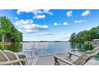 Expansive lake view from the dock with Adirondack chairs and blue sky at 8218 Bright Water Ln, Denver, NC 28037