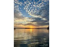 Picturesque sunset over the lake featuring a serene view of the calm waters and colorful sky at 8218 Bright Water Ln, Denver, NC 28037