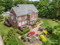 Aerial view of an outdoor living space with deck, patio, fire pit, and beautiful landscaping at 8962 Landsdowne Ave, Harrisburg, NC 28075