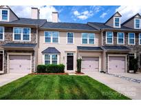 Charming townhome with a well-manicured lawn, attached garage, and stone accents at 9614 Springholm Dr, Charlotte, NC 28278