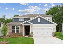 Charming two-story home featuring a brick facade, a two-car garage, and a well-manicured lawn at 9944 Manor Vista Trl, Kannapolis, NC 28027
