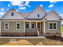 Charming home showcasing a welcoming front porch with brick accents and well-maintained landscaping at Lot 101 Coppergate Dr, Salisbury, NC 28147
