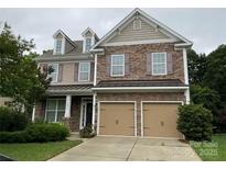 Two-story home showcasing a blend of stone and siding with a two-car garage and well-manicured lawn at 10817 Bere Island Dr, Charlotte, NC 28278