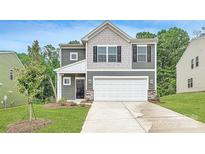 Charming two-story home featuring a stone-accented facade, a two-car garage, and manicured landscaping at 126 Dorian Pl, Troutman, NC 28166