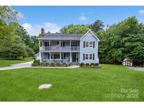 Charming two-story home with a spacious front yard and double covered porches, perfect for relaxing outdoors at 16612 Grapperhall Dr, Huntersville, NC 28078