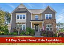 Charming two-story home featuring a stone and siding facade, manicured landscaping, and an inviting front porch at 16831 Alydar Commons Ln, Charlotte, NC 28278