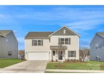 Charming two-story home boasts a manicured lawn, two-car garage, and classic architectural details at 1711 Wooten Way, Bessemer City, NC 28016