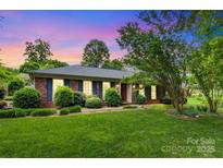Charming one-story brick home with lush green lawn and landscaping, inviting curb appeal at 1940 12Th Ne St, Hickory, NC 28601